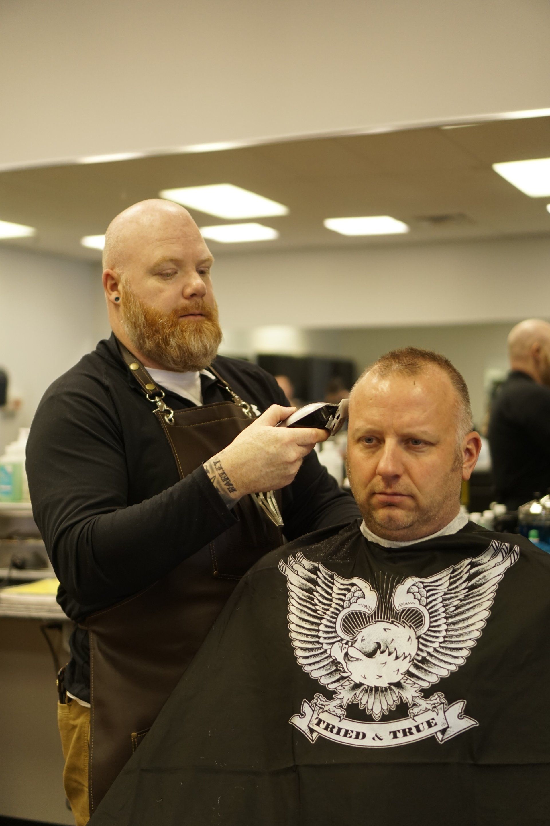 A man is getting his hair cut by a barber in a barber shop.