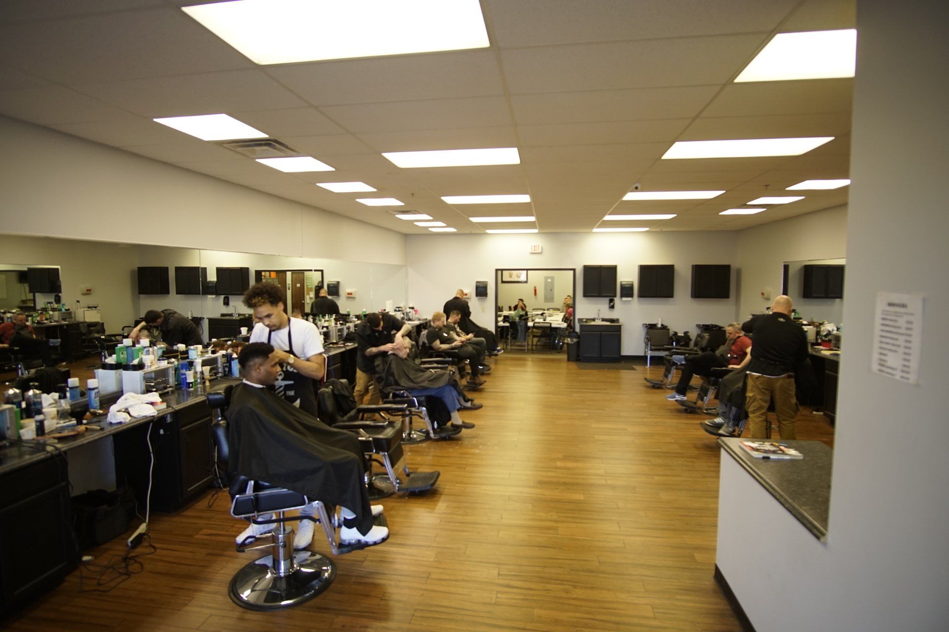 A man is cutting a man 's hair in a barber shop.