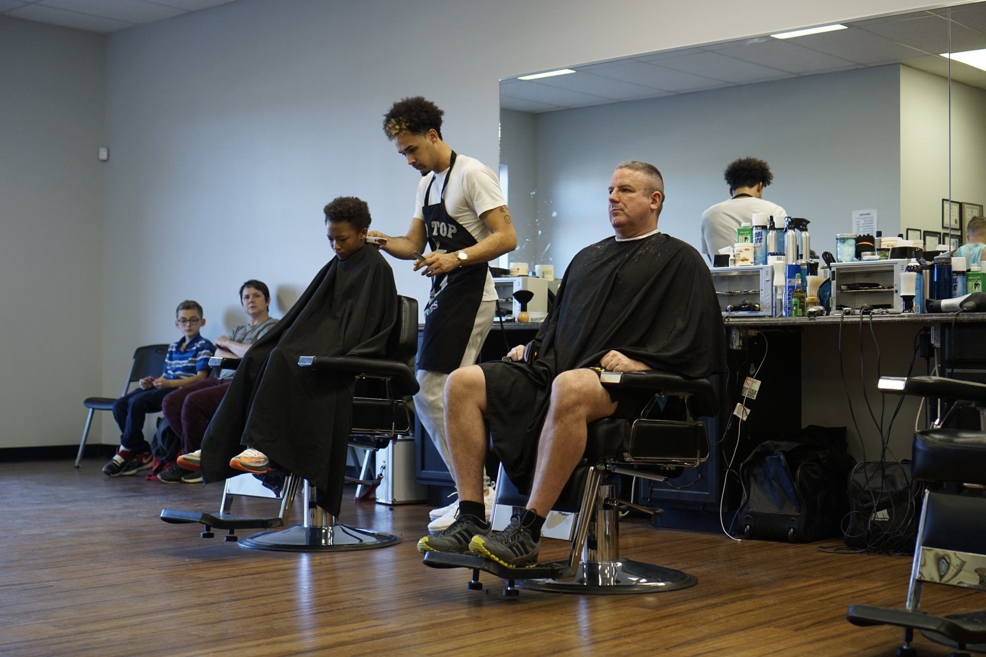 A man is getting his hair cut at a barber shop.