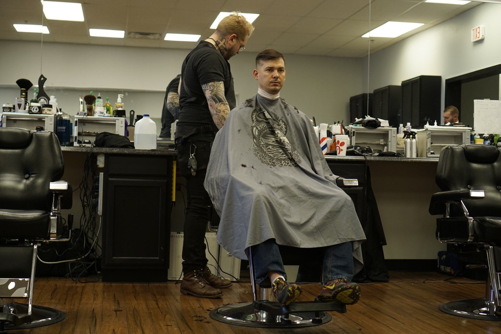 A man is getting his hair cut at a barber shop.