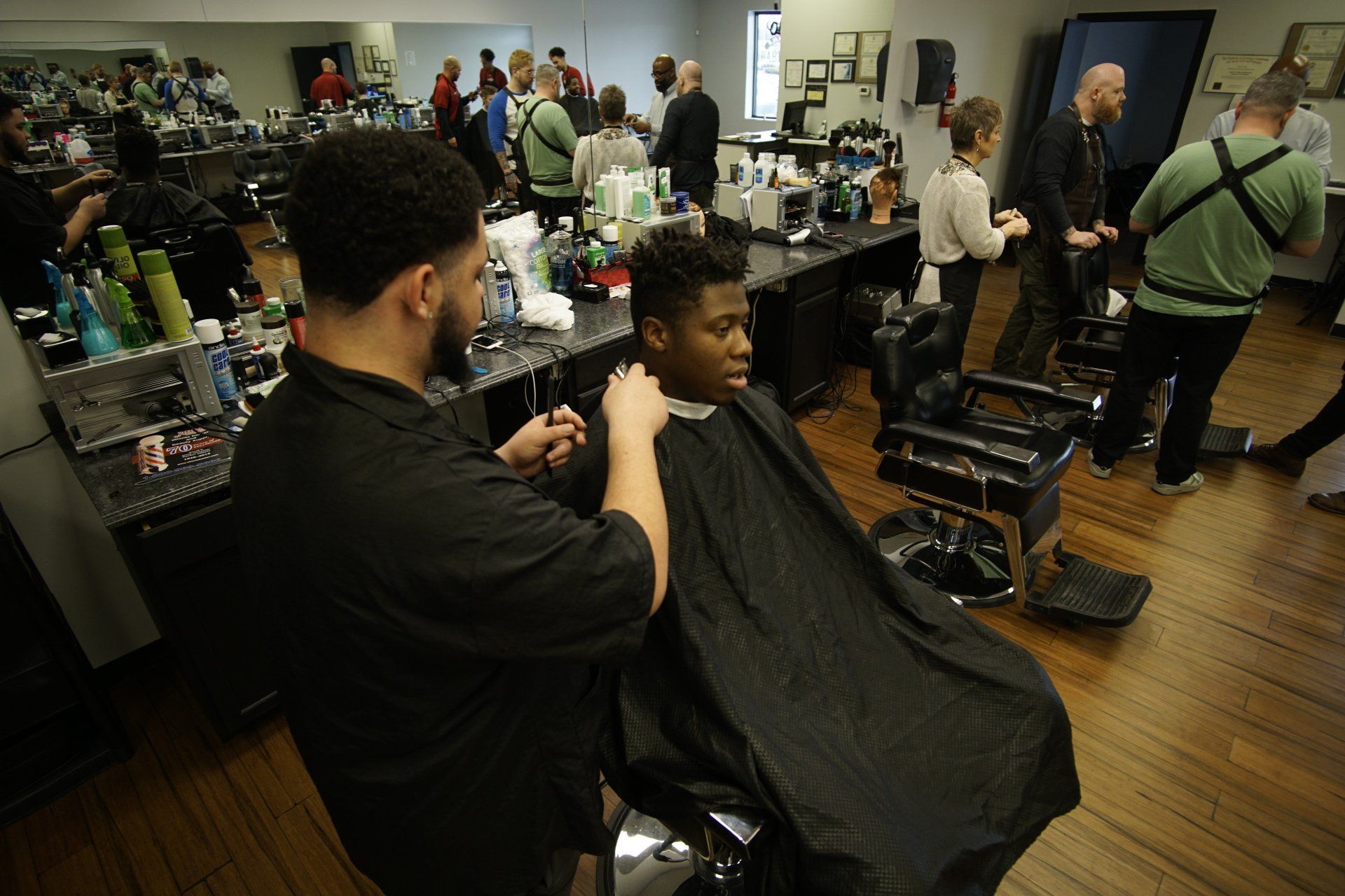 A man is getting his hair cut at a barber shop.