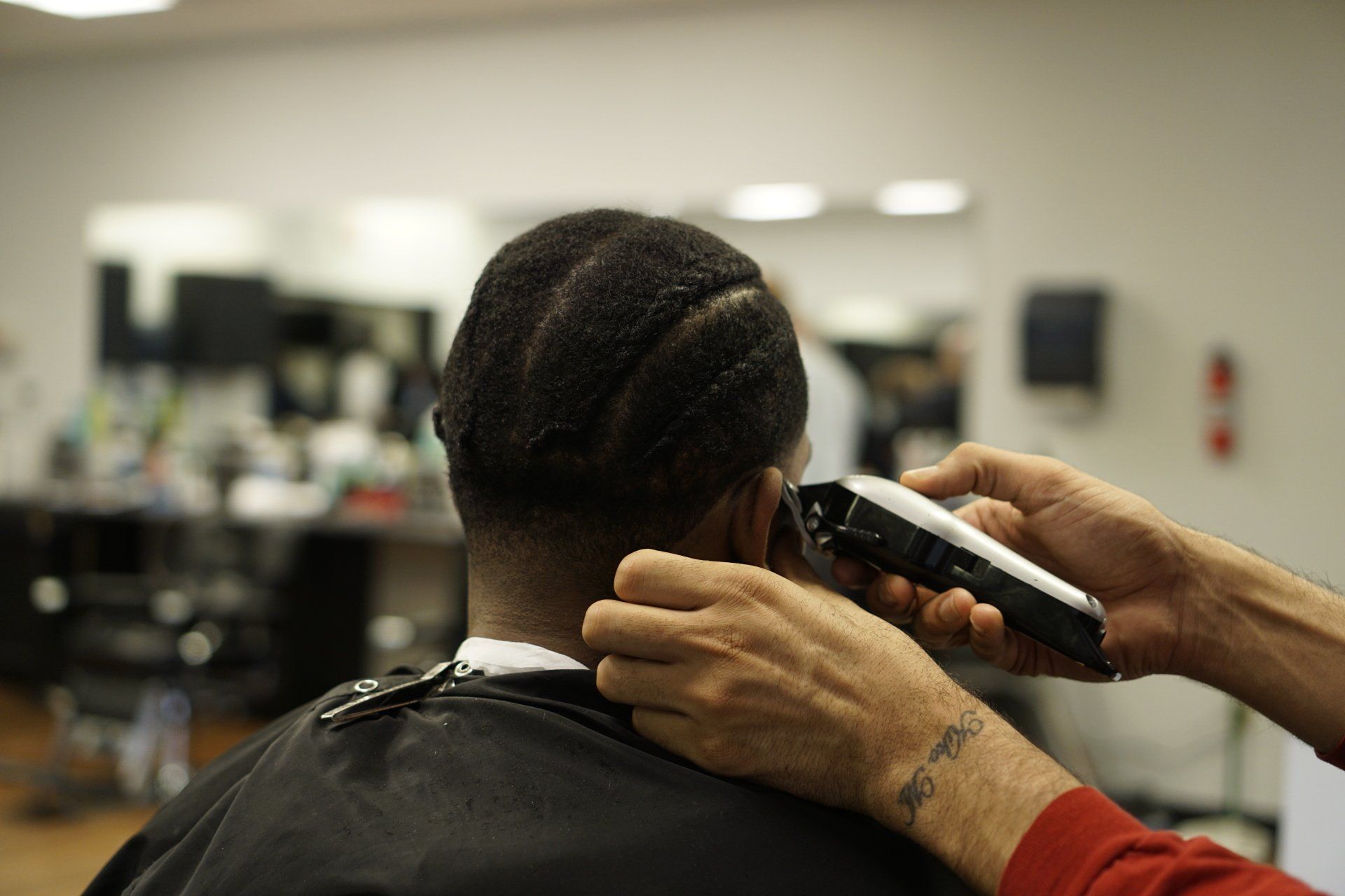 A man is getting his hair cut by a barber in a barber shop.