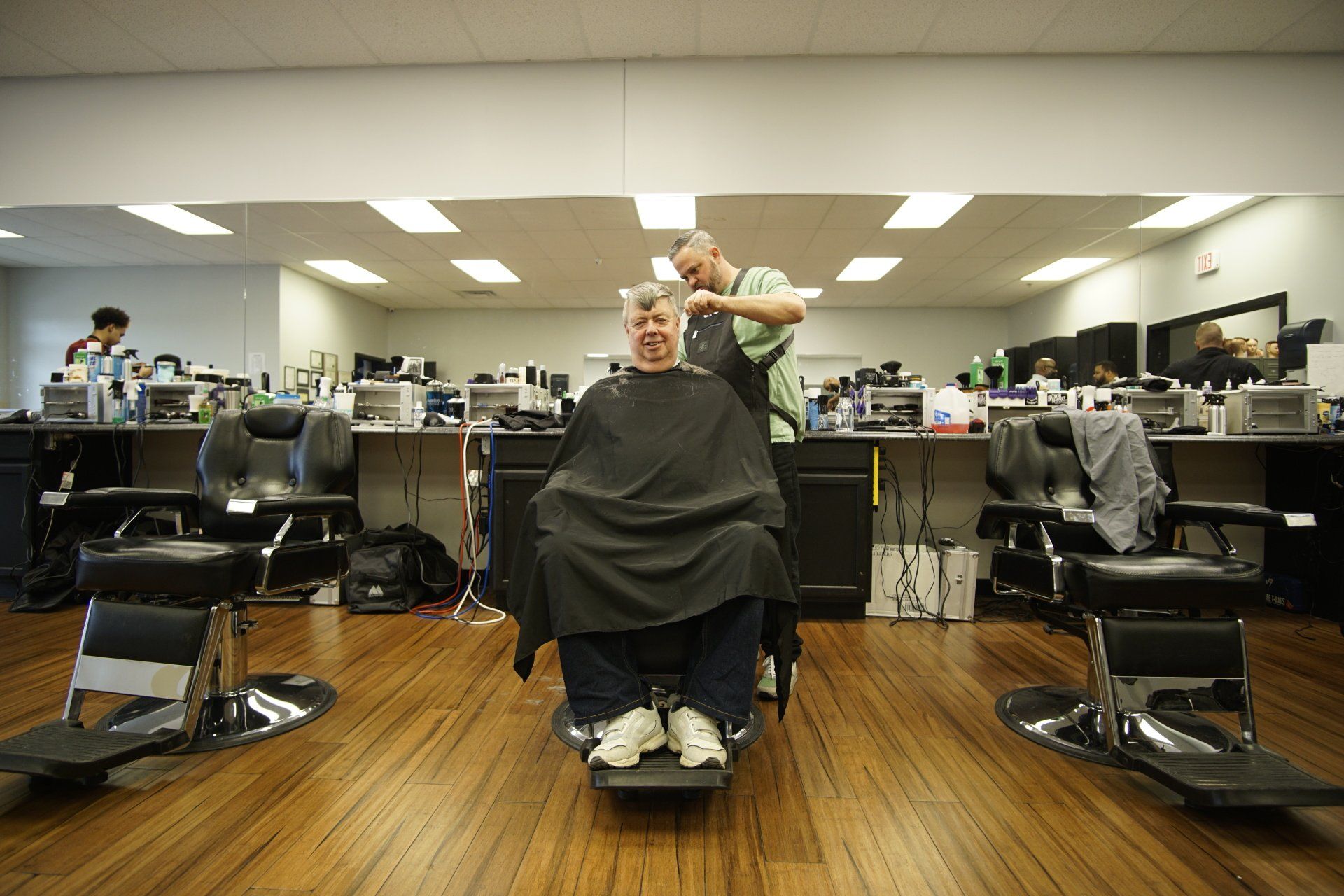 A man is getting his hair cut at a barber shop.