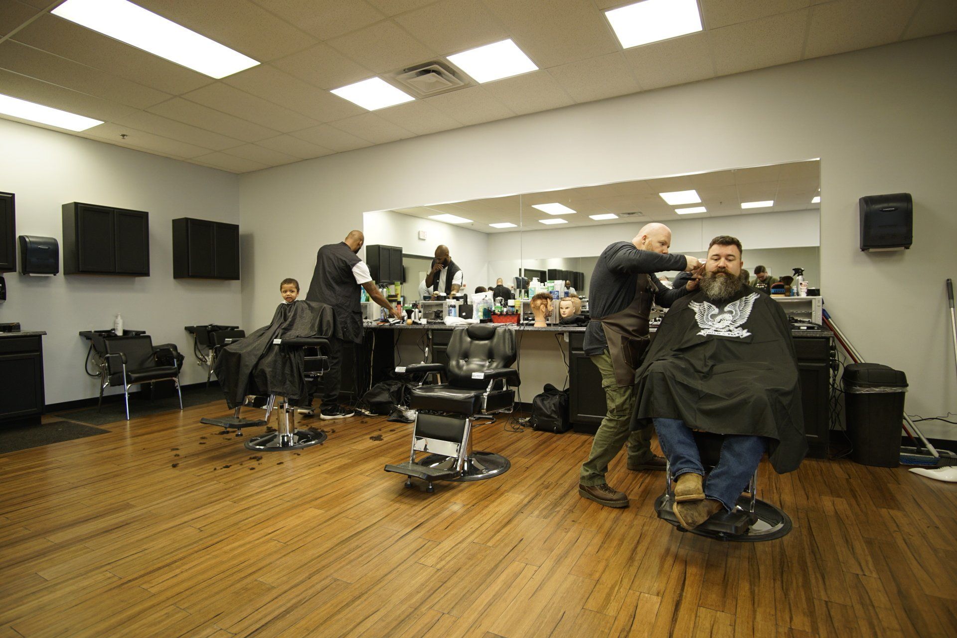 A man is getting his hair cut at a barber shop.
