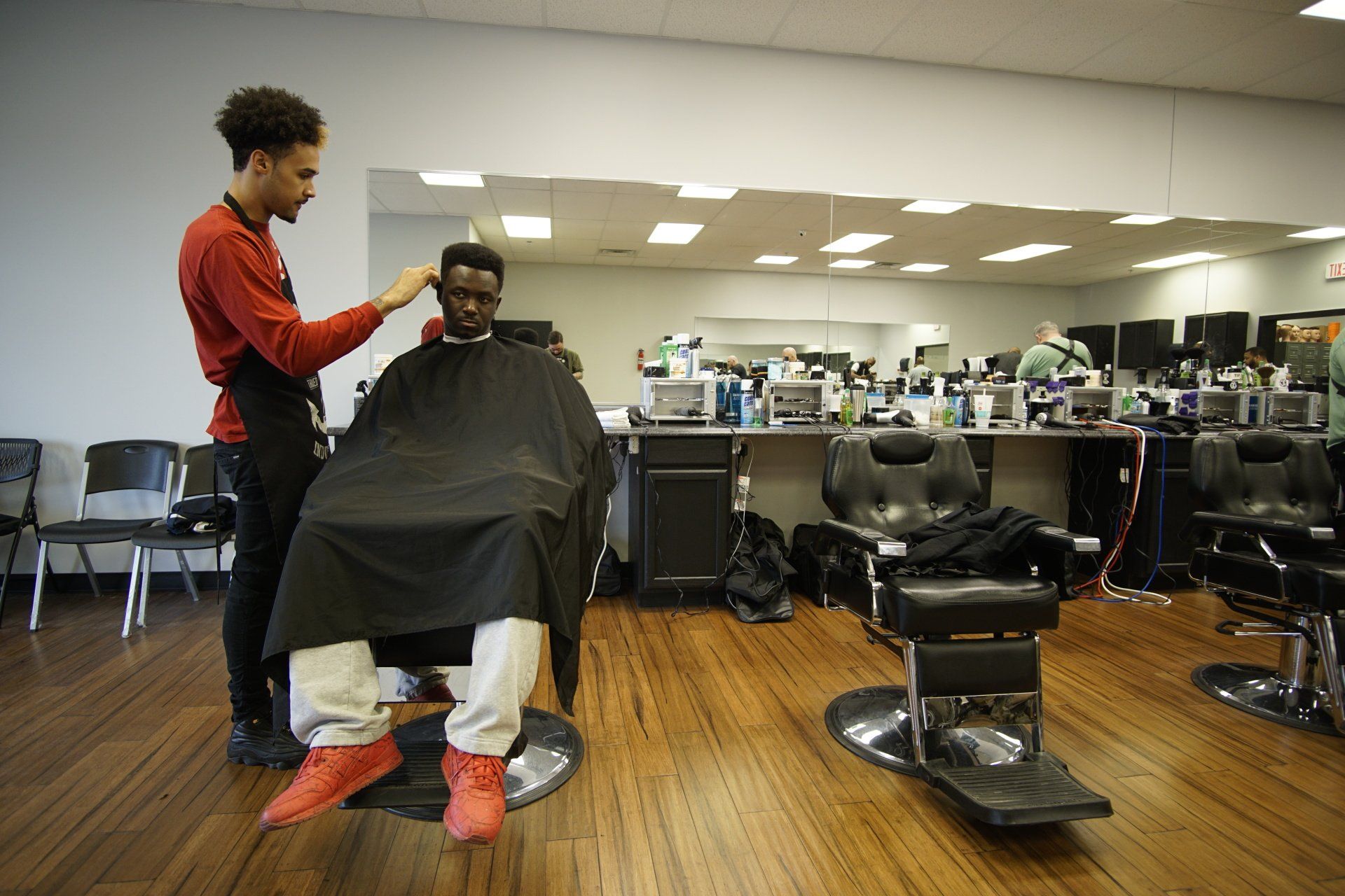A man is getting his hair cut at a barber shop.