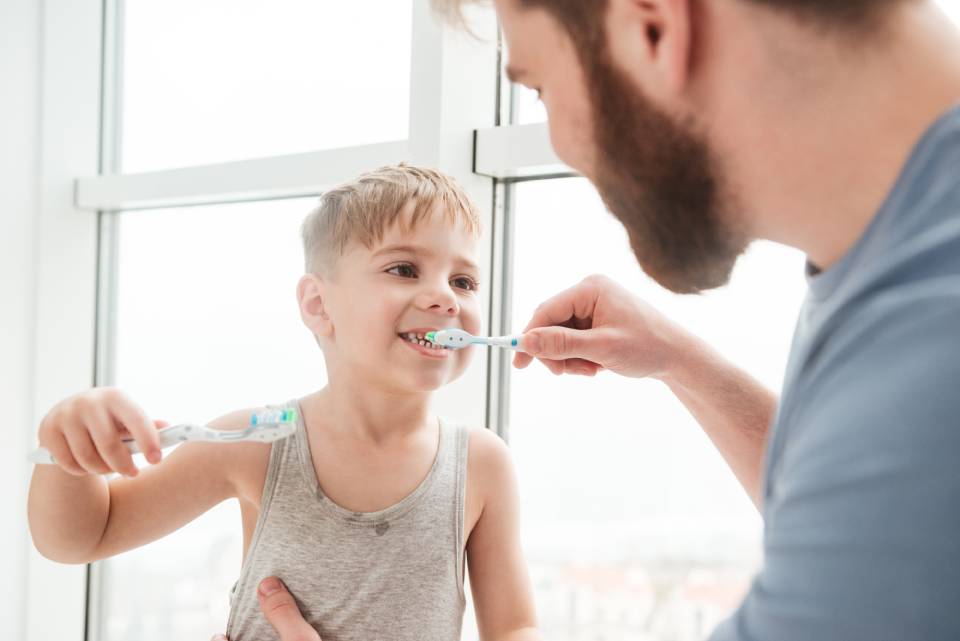papà insegna igiene orale al proprio bambino