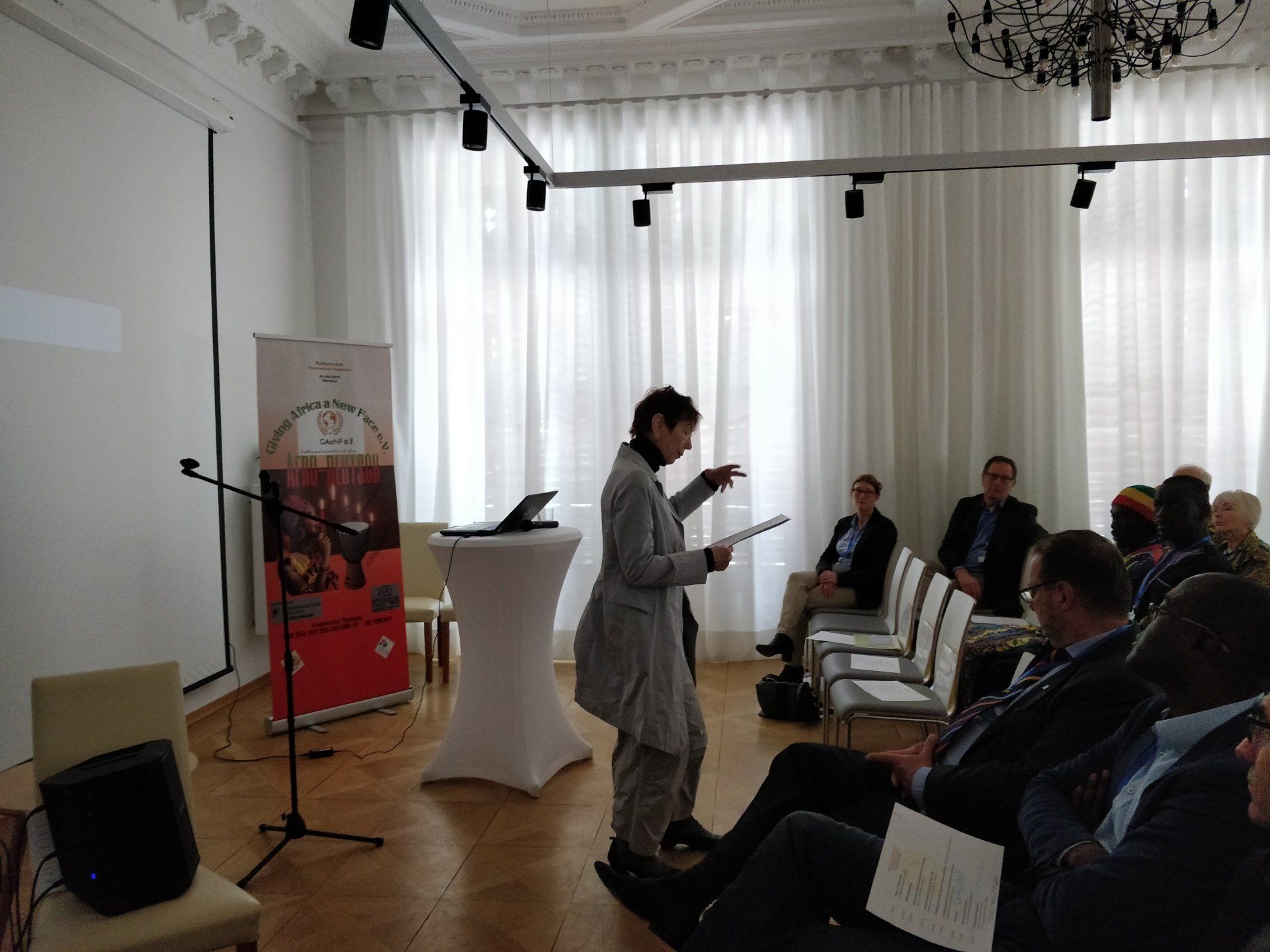 A woman is giving a presentation to a group of people in a room.