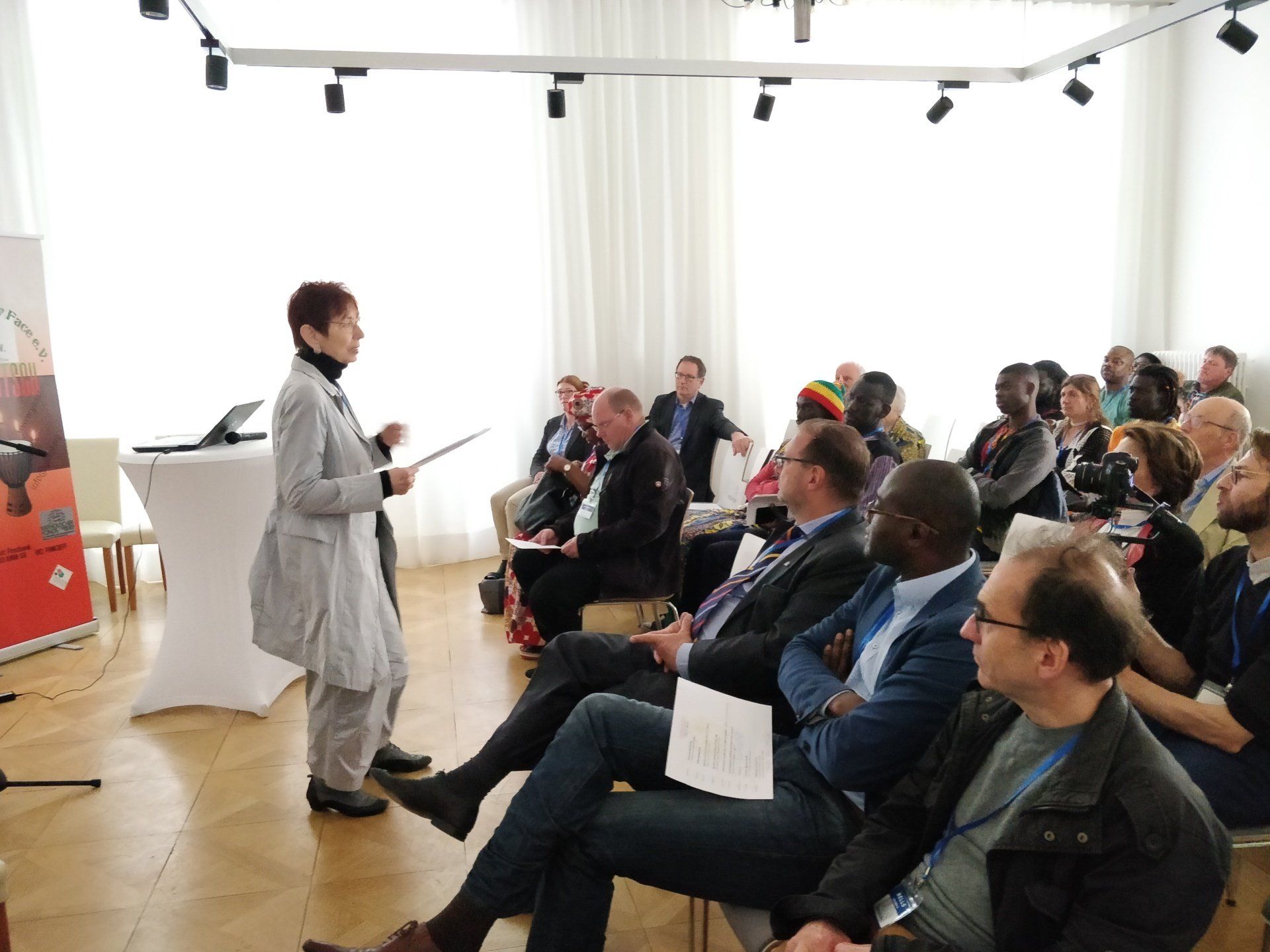A woman is giving a presentation to a group of people sitting in chairs.