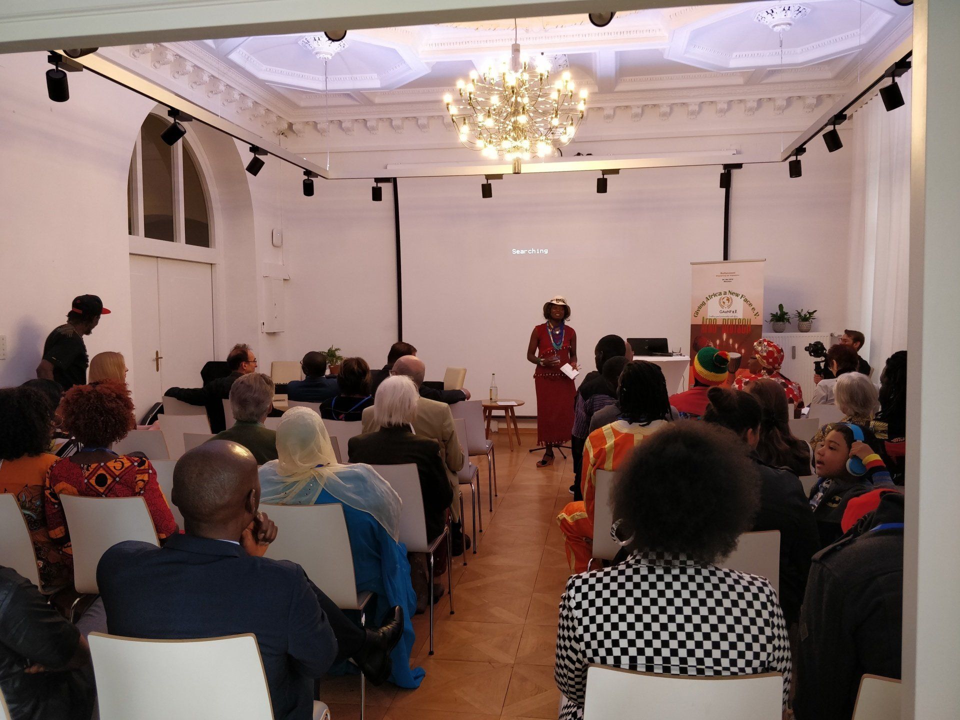 A woman is giving a presentation to a group of people in a large room.