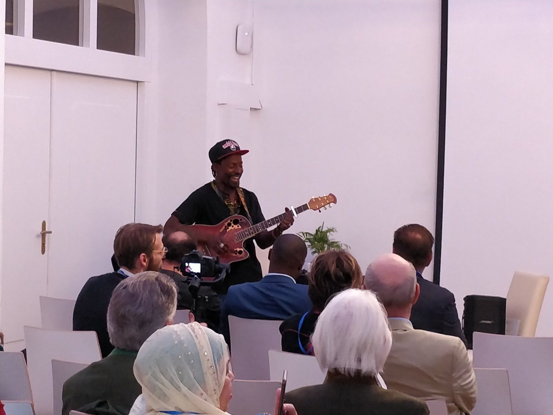 A man is playing a guitar in front of a group of people