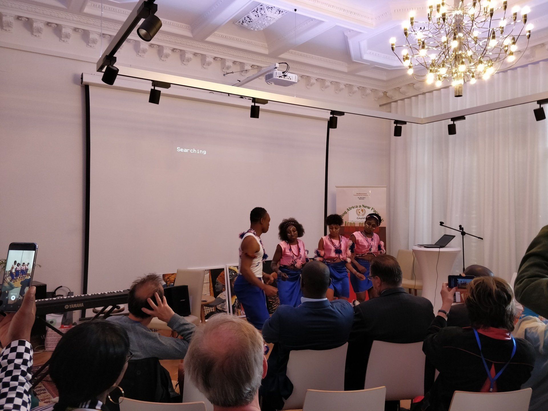 A group of people are sitting in a room watching a presentation