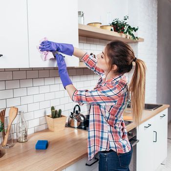 Housekeeping Services — Woman Cleaning The Cabinets in Florence, SC Housekeeping Services — Woman Cleaning The Cabinets in Florence, SC