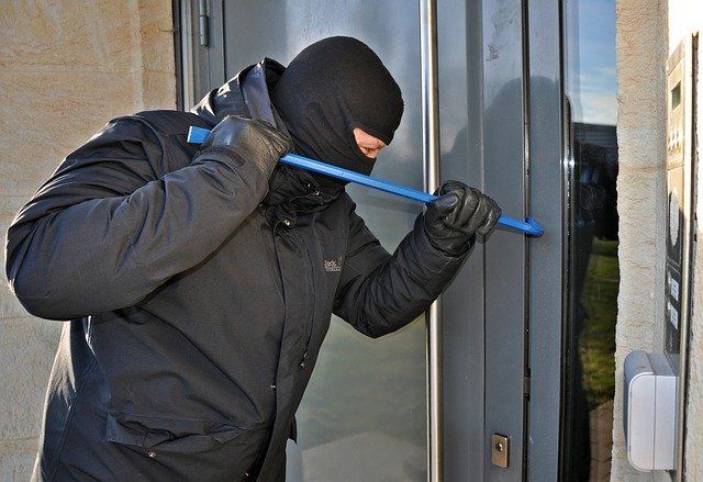 Bildbeschreibung im Sinne der Barrierefreiheit: Das Bild zeigt einen Mann, der mit einem Brecheisen eine Tür aufhelbelt. Bildbeschreibung im Sinne der Barrierefreiheit: Das Bild zeigt einen Mann, der mit einem Brecheisen eine Tür aufhelbelt.