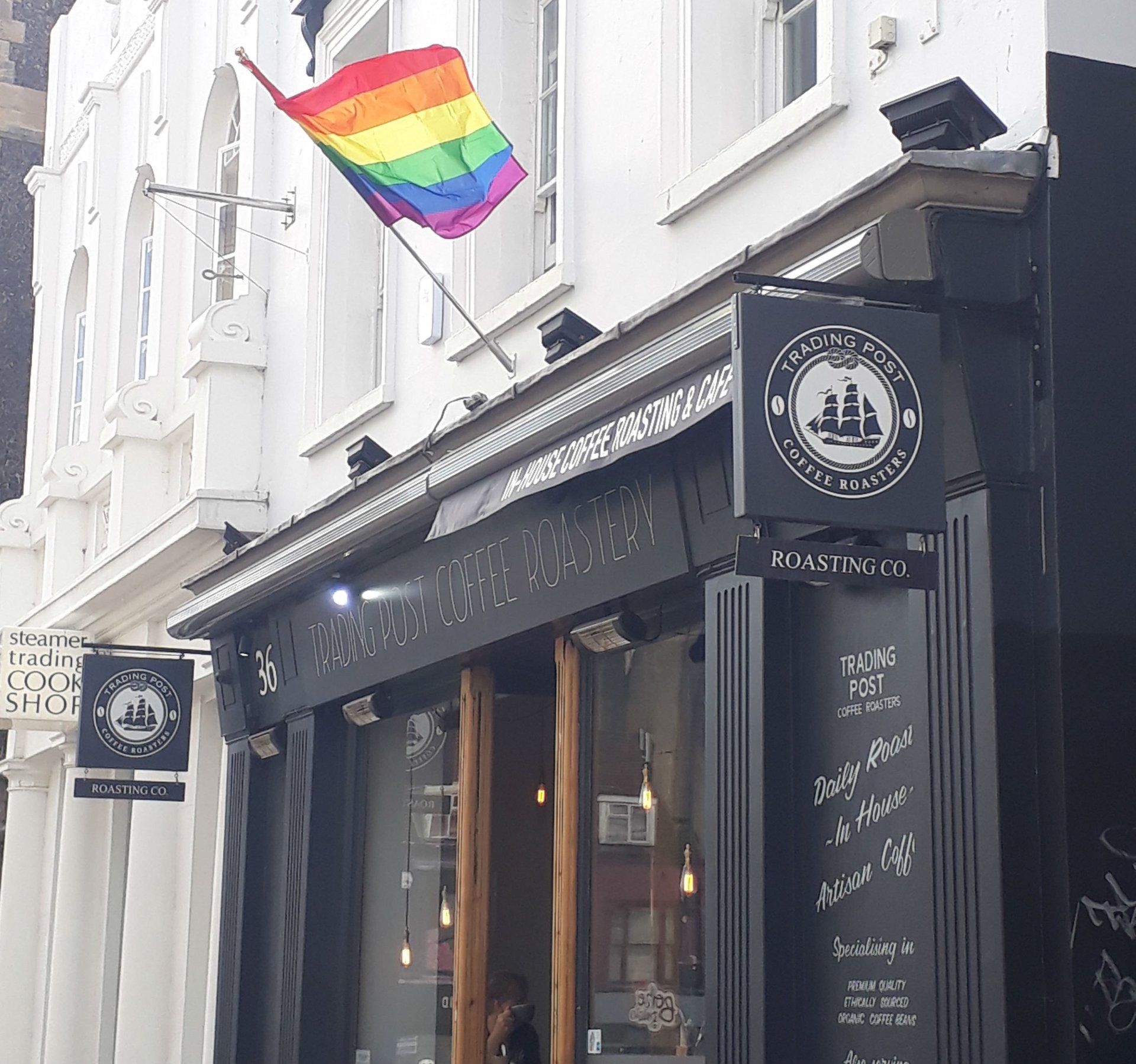A rainbow flag is hanging from the side of a building
