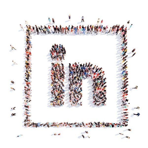 A large group of people are gathered in the shape of the linkedin logo.