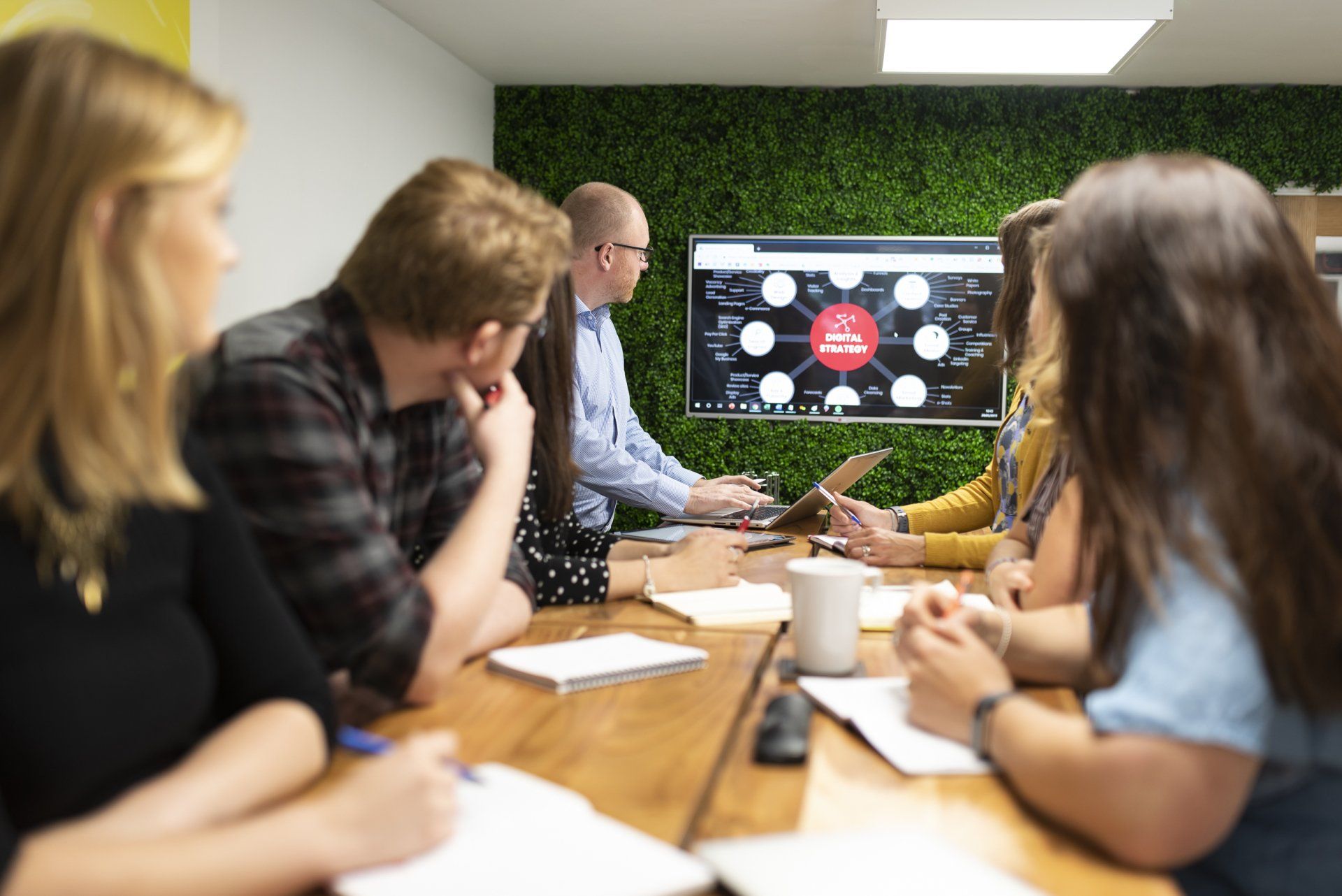A group of people are sitting around a table in a conference room.