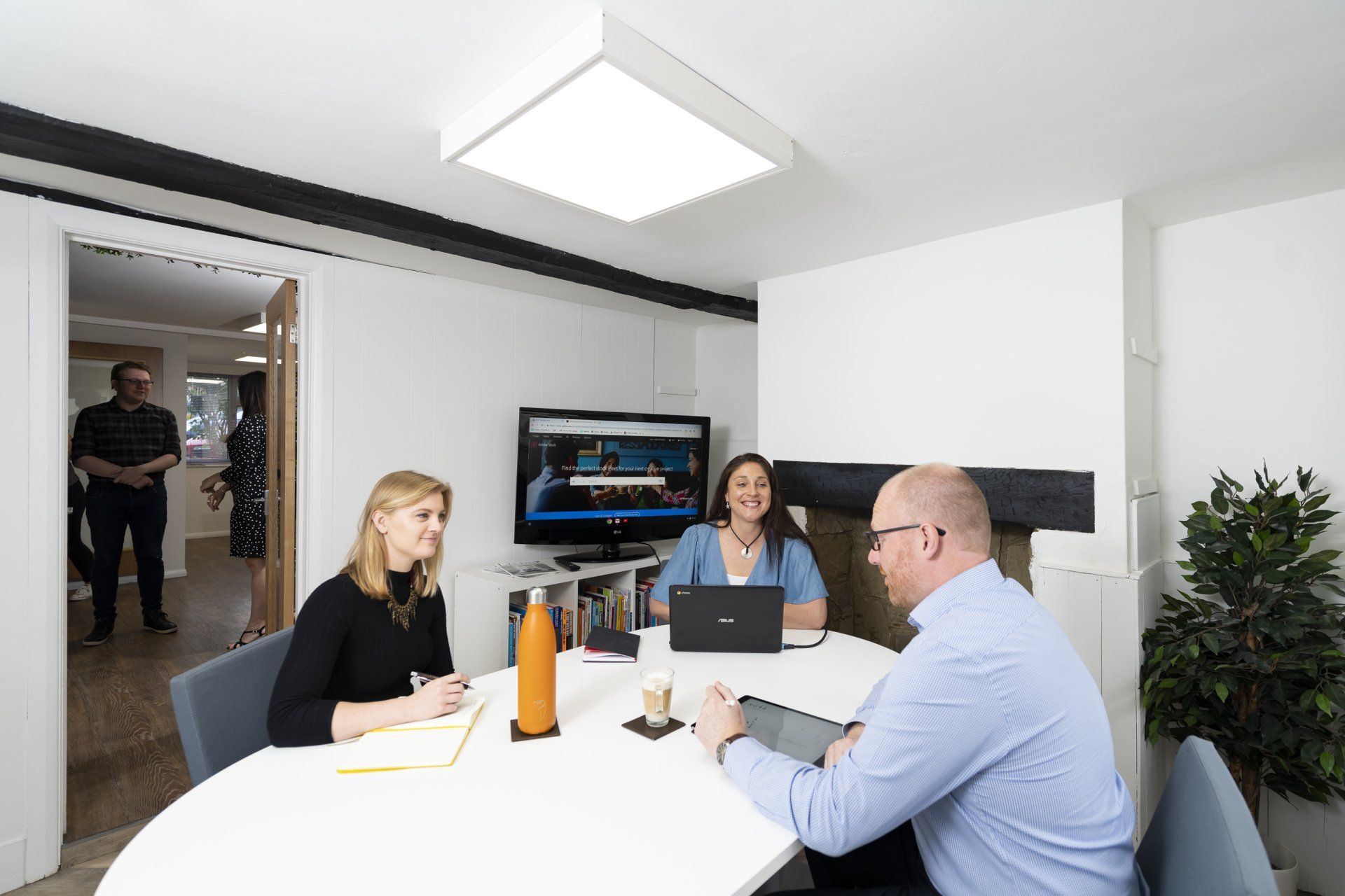 A group of people are sitting around a table in a conference room.