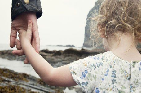 child walking with her father