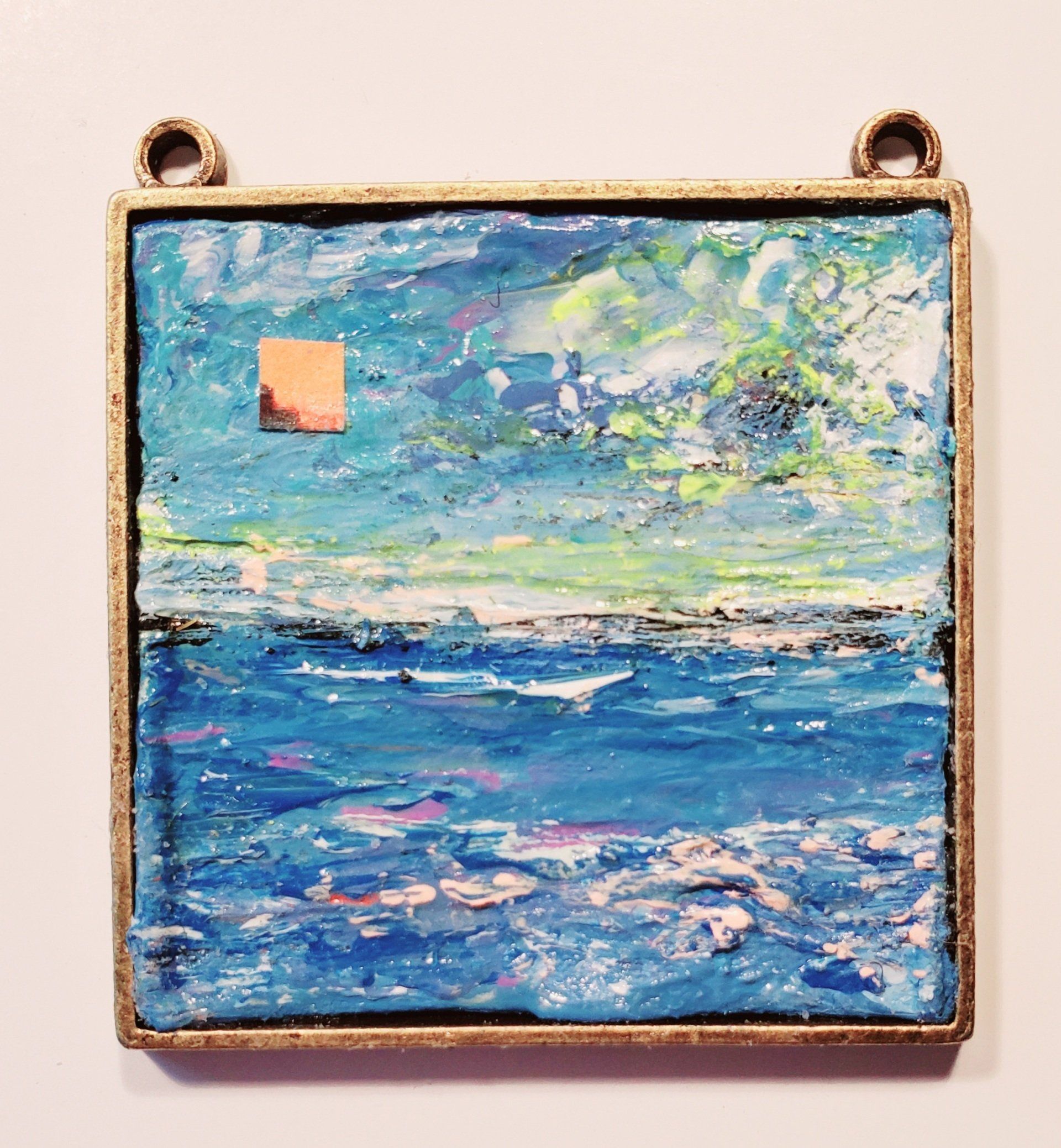 A painting of a blue ocean in a gold frame