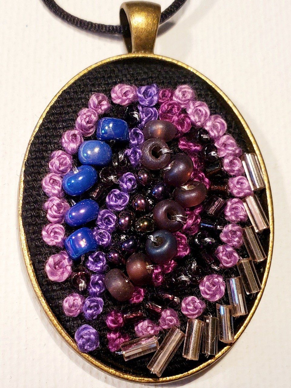 A pendant with purple and blue beads on it