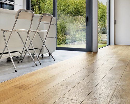 Wooden floor in a Modern apartment interior with french windows and lush garden
