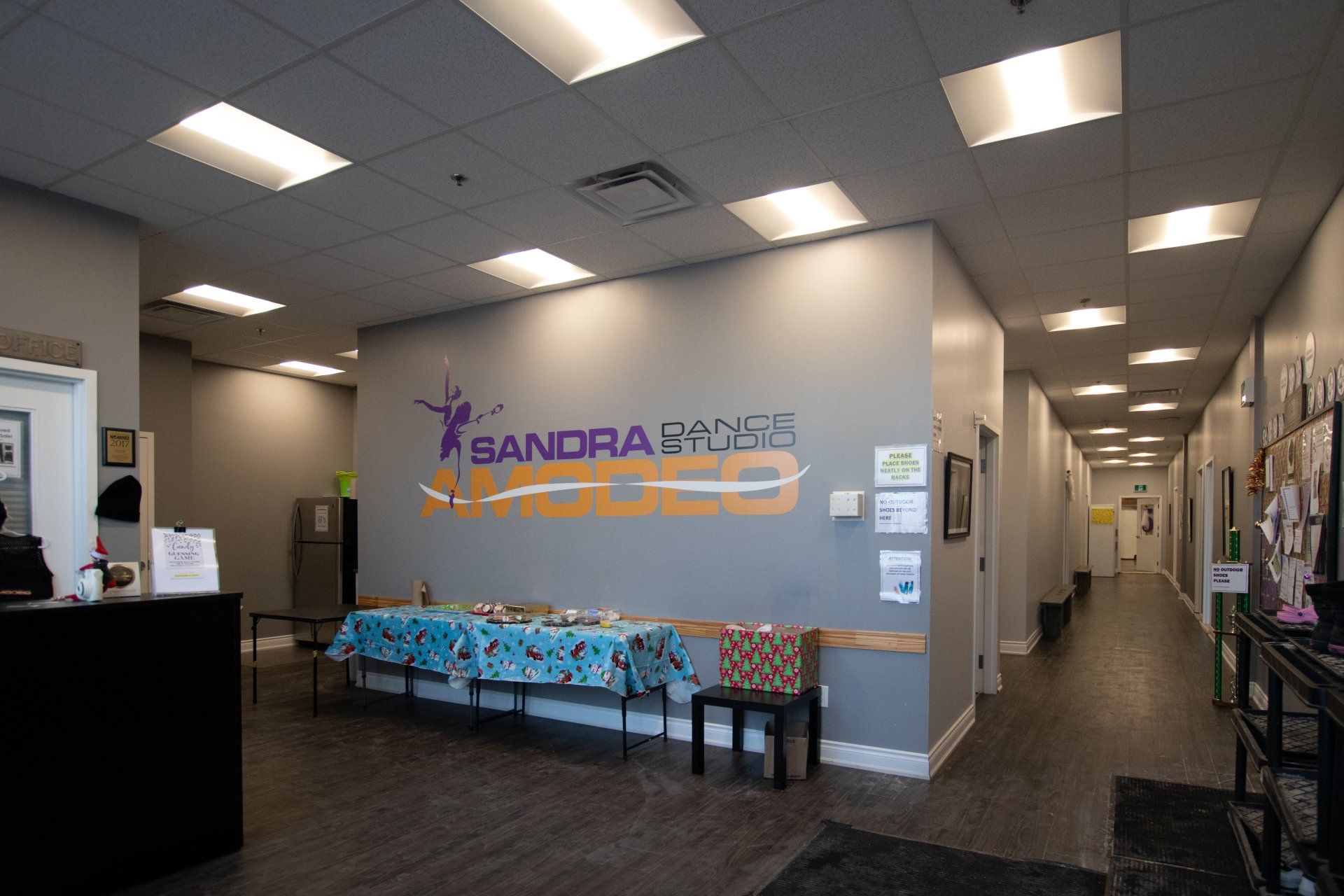 Indoor office lobby with brand signage, blue seating, and a hallway leading deeper inside