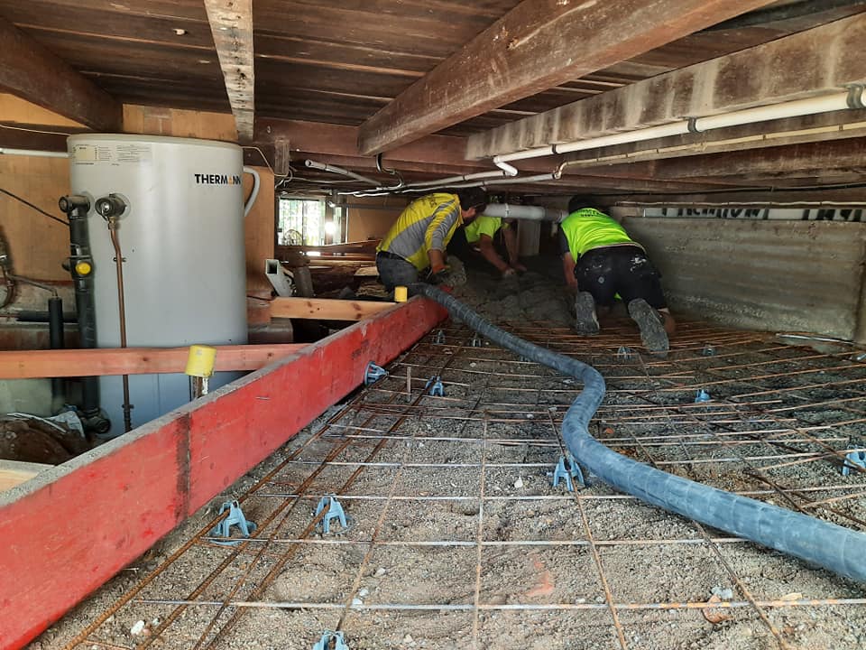 Workers concrete pumping under house — About Us in Townsville, QLD