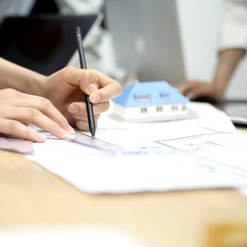 person holding pen drafting plans