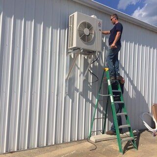 Repairing Aircon Outdoor Unit — Commercial HVAC Contractors in Mount Vernon, OH Repairing Aircon Outdoor Unit — Commercial HVAC Contractors in Mount Vernon, OH