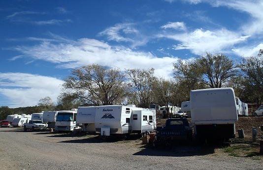 A row of rv 's are parked in a parking lot.