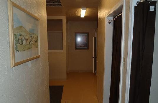 A hallway with a painting on the wall and a picture on the wall.