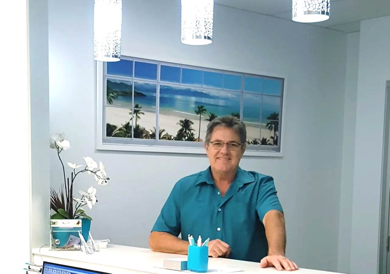 Ray Lewis Osteopath standing at his clinic reception counter