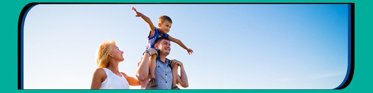 Father carrying son on shoulders at beach