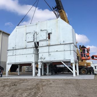A large white building is being lifted by a crane