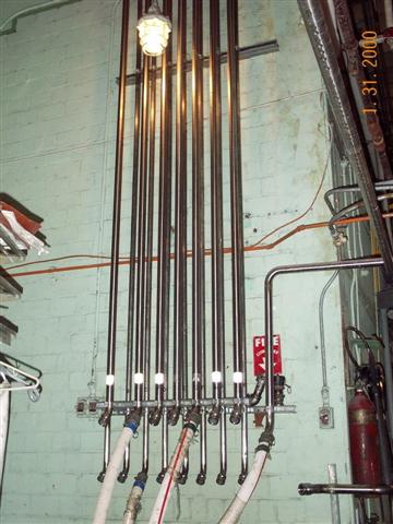 A bunch of pipes are hanging from the ceiling in a room.