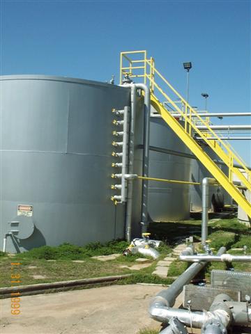 A large gray tank with a yellow staircase leading up to it