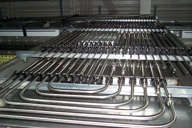 A bunch of metal pipes are lined up on a table