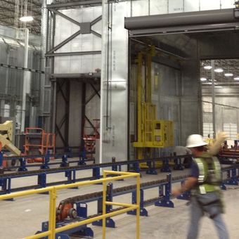 A man in a hard hat is walking through a factory
