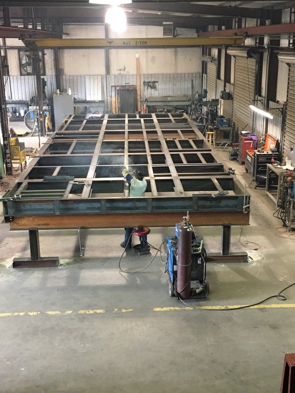 A large metal structure is being built in a factory