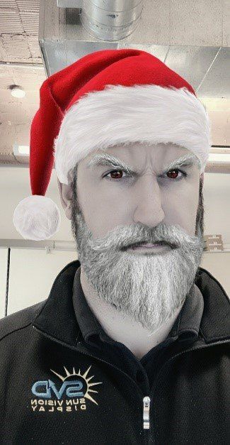 A man with a santa hat and beard is wearing an av2 jacket