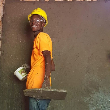 a person wearing a hard hat and holding a trowel