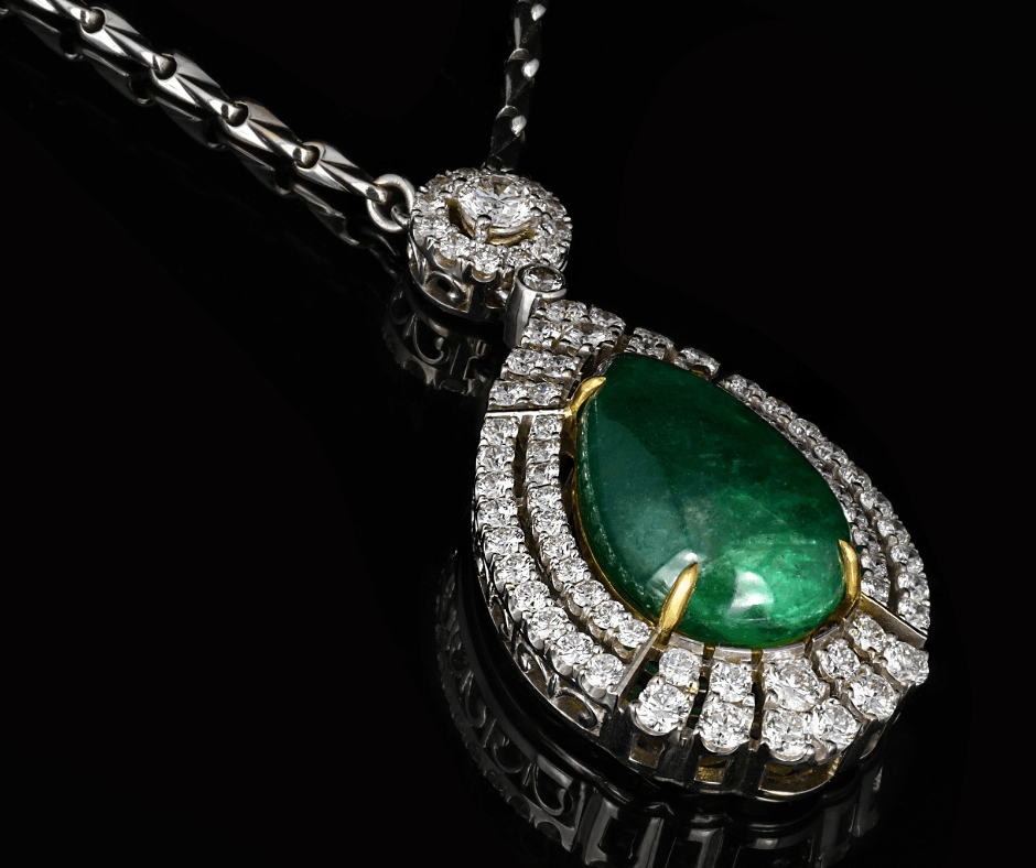 Green gemstone pendant with diamond halo on a chain, photographed on a dark background