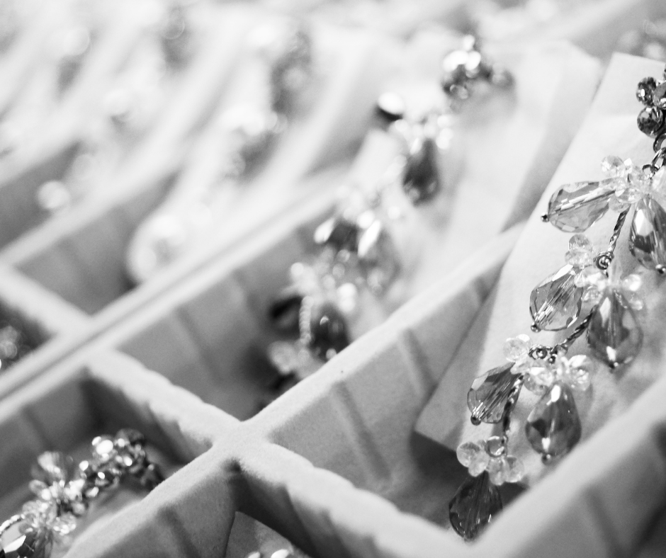 Black-and-white close-up of jewelry in compartmented display boxes
