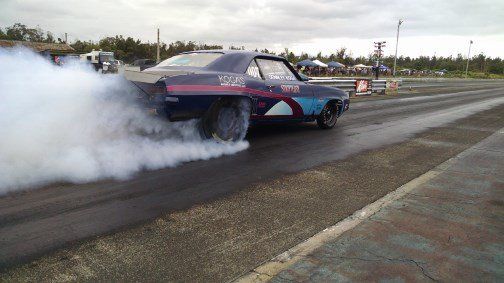A car is doing a burnout on a race track