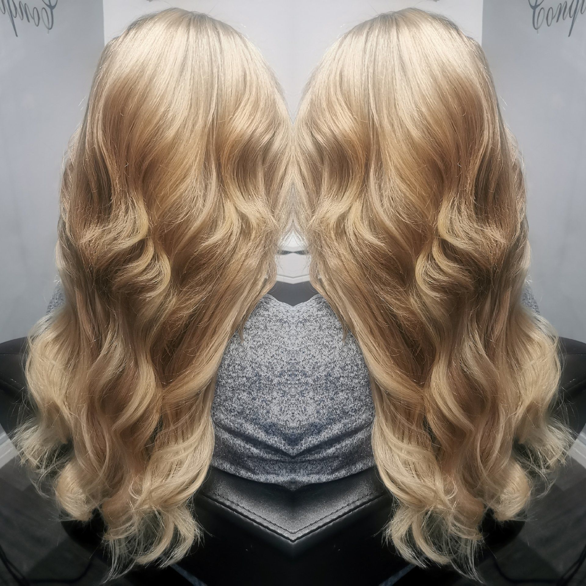A woman 's blonde hair is reflected in a mirror