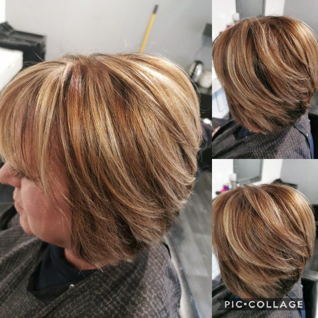 A woman is getting her hair cut in a salon.