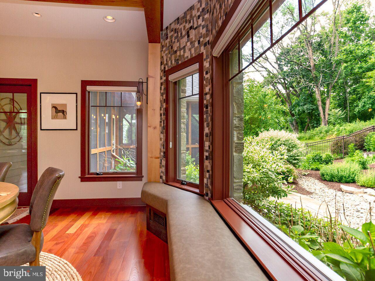 A dining room with hardwood floors and a large window