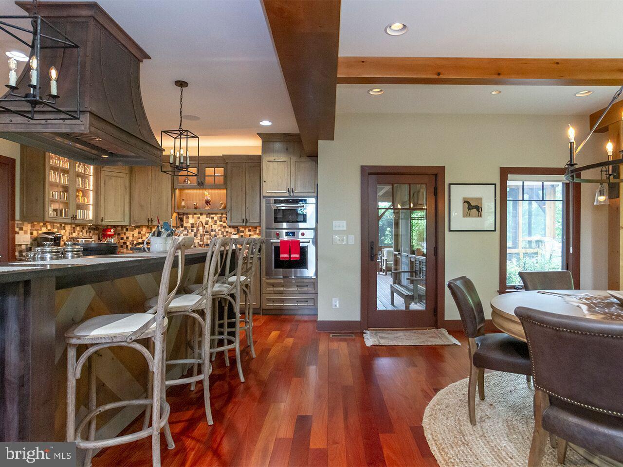 A kitchen and dining room in a house with hardwood floors.