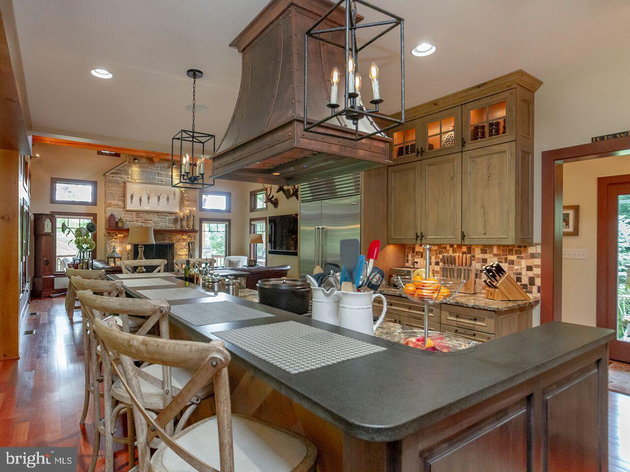 A kitchen with a large island and chairs in it.