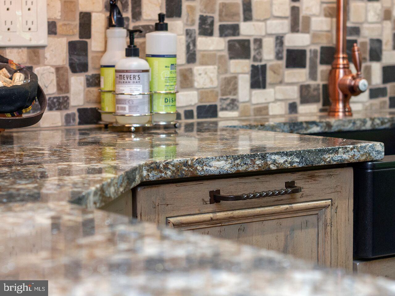A kitchen counter with granite counter tops and a sink.